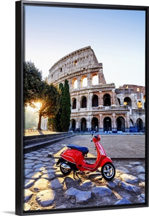 Italy, Rome, a red Vespa motorbike in front of Colosseum at sunrise