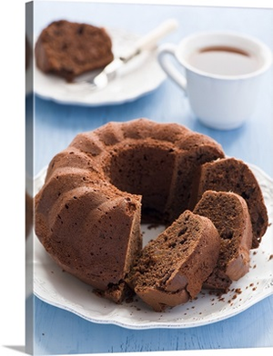 Chocolate cake in white plate and cup of tea.